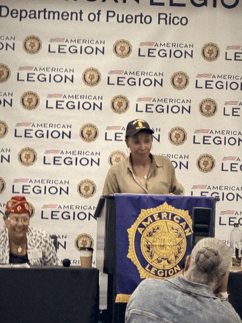 Adjutant Michele S. Jones speaking at the podium under the Department of Puerto Rico banner